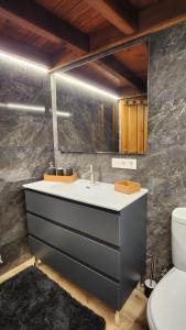 ein Badezimmer mit Waschbecken und Toilette in der Unterkunft Vivienda vacacional El Cau - Casas de Los Picos in Ruenes + 14 Fotos