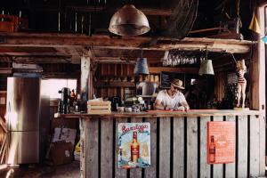 a man standing behind a bar with a bottle of alcohol at Hotel Toftagården in Tofta