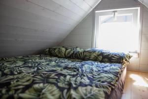łóżko w pokoju z oknem w obiekcie Bursztynowe Domki w Helu w mieście Hel
