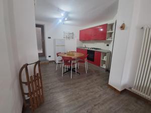 a kitchen with a table and chairs and red cabinets at Le Sapin des Vuillermin CIR0080 in Saint Vincent
