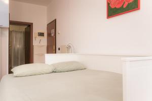 a white bed with a pillow on top of it at Casa Alura in Bergamo