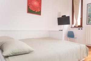 a bedroom with a white bed and a blue chair at Casa Alura in Bergamo +11 photos