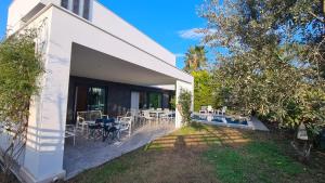 a white house with a patio with tables and chairs at Уютная вилла в Чамьюва in Kemer