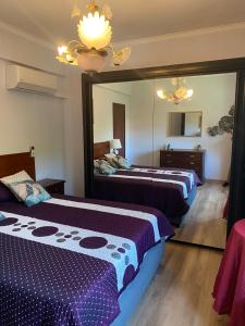 a bedroom with two beds and a large mirror at Cotovia Lodge in Sesimbra +4 photos