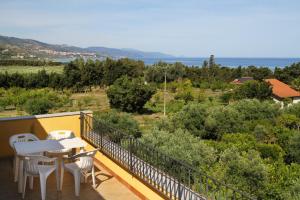 een balkon met een tafel en stoelen en de oceaan bij Il giardino al mare di Anna in Caronia Marina