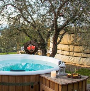 a jacuzzi tub in a yard with a tree at Green Apartment in Rosolina Mare