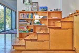 a library with wooden shelves and bookshelves at The Lookout House at Pirates Bay in Eaglehawk Neck