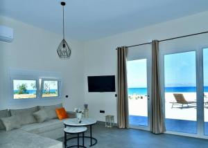 a living room with a couch and a view of the ocean at Lambou Beach Sunset in Soroni