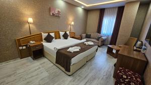 a hotel room with a large bed and a desk at POINTBREAK OTEL in Degirmen