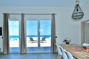 a dining room with a table and a view of the ocean at Lambou Beach Sunset in Soroni
