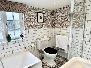 a bathroom with a toilet and a bath tub at Worlington Hall in Worlington