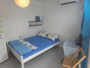 une petite chambre avec un lit et une chaise dans l'établissement Luna Beach Apartment, à Novalja 7 autres photos