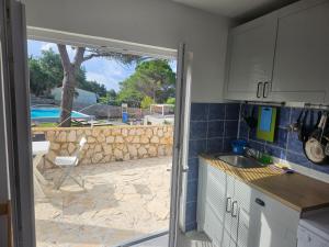 une cuisine avec vue sur une cour avec un patio dans l'établissement Luna Beach Apartment, à Novalja