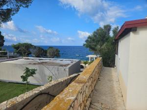 un mur de soutènement à côté d'un bâtiment et de l'océan dans l'établissement Luna Beach Apartment, à Novalja