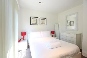 ロンドンにあるModern and Brand New Flat In Central Londonの白いベッドルーム(白いベッド1台、ランプ2つ付)