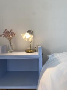 une table avec une lampe à côté d'un lit dans l'établissement Kiki's, à Castagnole Lanze