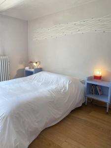 une chambre avec un lit blanc et une table de nuit bleue dans l'établissement Kiki's, à Castagnole Lanze