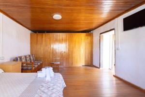 Las RosasにあるCasa El Rincón I, San Andrés, El Hierroのベッドとソファがあり、木製の天井がある部屋