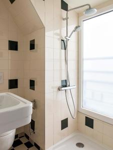 uma casa de banho com um chuveiro e um lavatório. em Hôtel Dalila em Paris