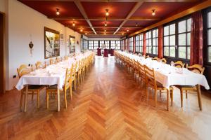 a long banquet hall with white tables and chairs at Zur Alten Post in Nottuln