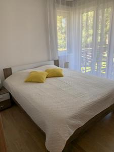a bed with two yellow pillows in a bedroom at Karusselli 66a in Pärnu