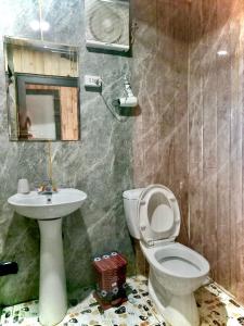 a bathroom with a toilet and a sink and a mirror at VALLEY VIEW COFFEE & STAY in Sa Pa