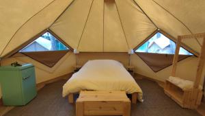 Bett in einem Zelt mit zwei Fenstern in der Unterkunft Camping Pla de la Torre in Sant Antoni de Calonge