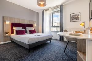 Nemea Appart Hotel Grand Cœur Nancy Centre في نانسي: غرفة الفندق بسرير وطاولة