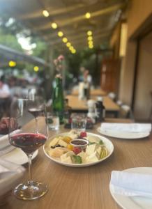 a plate of food on a table with a glass of wine at Hotel Marathon in Senec