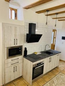 una cucina con lavello e fornello di Casa Cueva Candelaria - Alcalá del Júcar ad Alcalá del Júcar Altre 6 foto
