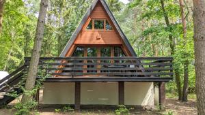 a cabin in the woods with a triangular roof at VIVA SOLE domek nr 8 in Skorzęcin