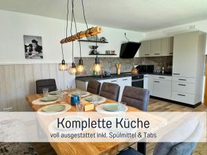 a kitchen and dining room with a table and chairs at Nur 15 Minuten bis Fulda - ideal zum Arbeiten - Am Vulkanradweg - 3 Schlafzimmer Große Terrasse - Grill - Ferienhaus Taufstein 1 in Herbstein
