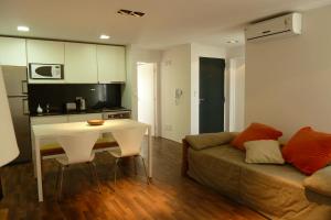 a living room with a couch and a table and a kitchen at El Terrado I in Las Grutas