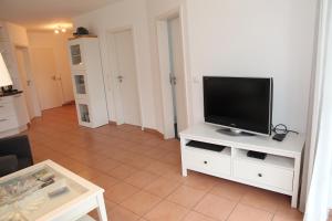 a living room with a flat screen tv on a white cabinet at Ebbe in Norden