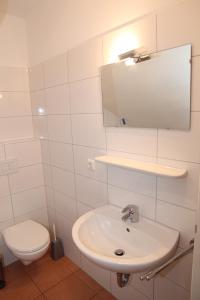 a bathroom with a sink and a toilet and a mirror at Ebbe in Norden +6 photos