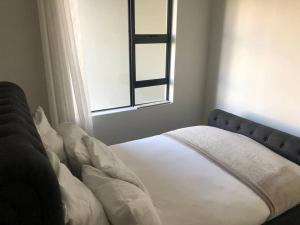 una cama en un dormitorio con ventana en Exquisite Home In Sandton with Pool and Inverter, en Johannesburgo 36 fotos más