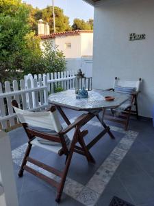 un tavolo e sedie su un patio con recinzione di Casa Martina 2 (Spata) 10min El.Venizelos airport. a Spata