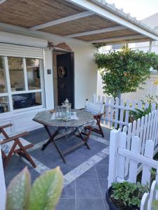 patio con tavolo e sedie bianche di Casa Martina 2 (Spata) 10min El.Venizelos airport. a Spata
