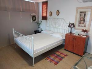 una camera con letto bianco e pavimento in legno di Casa Martina 2 (Spata) 10min El.Venizelos airport. a Spata