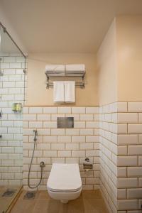 uma casa de banho branca com WC e toalhas em Bloom Hub I Western Highway em Mumbai