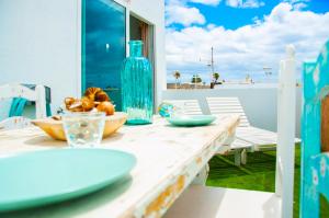une table avec un vase bleu et des assiettes dessus dans l'établissement Callao beachhouse, à Playa Honda