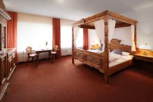 a bedroom with a large canopy bed and a table at Zur Alten Post in Nottuln