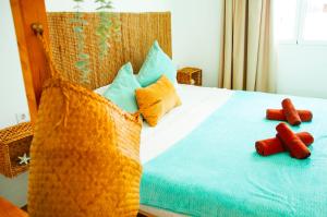 a bed with orange and blue sheets and pillows at Callao beachhouse in Playa Honda