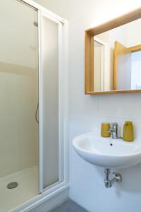 La salle de bains est pourvue d'un lavabo et d'une douche. dans l'établissement Apartamento del Mercado, à Cadix