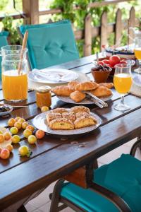 een houten tafel met borden en glazen sinaasappelsap bij Gioia Traditional House in Ágios Nikólaos