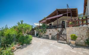 een stenen huis met een hek bij Gioia Traditional House in Ágios Nikólaos