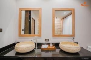 two sinks in a bathroom with two mirrors at Malabar Pool Villa Phuket in Phuket