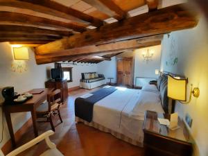 a large bedroom with a large bed and a desk at Villa Curina Resort in Castelnuovo Berardenga