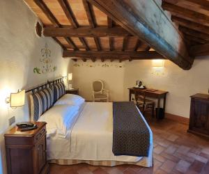 a bedroom with a bed and a desk in a room at Villa Curina Resort in Castelnuovo Berardenga