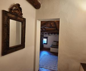 un espejo colgado en una pared al lado de un pasillo en Villa Curina Resort en Castelnuovo Berardenga